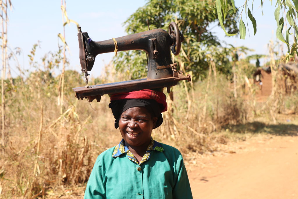 woman carrying sewing machine on her head