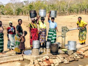 Malawi women gather water from a new well