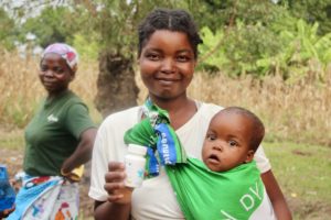 Malawian mother smiling and receiving vitamins